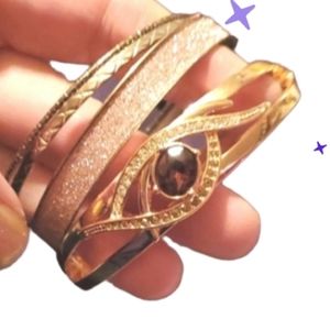 New Avon goldtone hinged cuff, white crystals and purple center stone